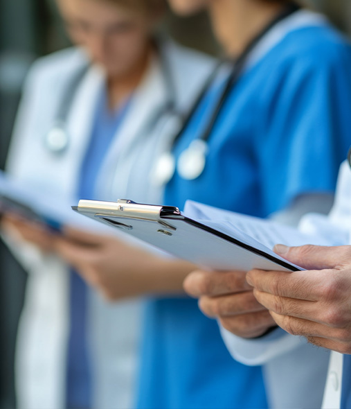 medical professionals reviewing notes with clipboards in a healthcare setting emphasizing collaboration and teamwork in patient care