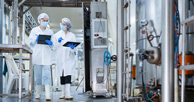business meeting with multiple hands engaged in discussion over graphs and charts on a table using tablet and laptop showing two key financial strategies